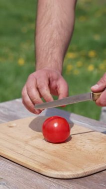 İnsan eli olgun domatesleri keser. Organik sebze dilimleme. Dikey video