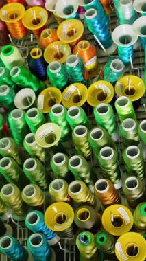 Duvarda asılı renkli iplikler dikmek. Pamuk aksesuarlar tasarla. Dikey video