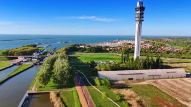 Lelystad 'daki Markermeer Gölü' nün inanılmaz yeşil su manzarası. Drone uçağı telekom kulesine yaklaşıyor. Arka plandaki yat kulübü. Hava görünümü.
