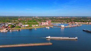 Boş mavna göl manzarasında yavaşça hareket ediyor. Hollanda, Lelystad 'ın manzarasına hava perspektifi.