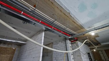 Eski bina tadilatı. Tesisin tavanındaki borular ve kablolar. Düşük açı görünümü.