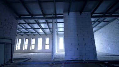 Yenilenmiş binanın içi. Yeni çatının altında yeni yapılmış beyaz tuğla duvarlar. Düşük açı görünümü.