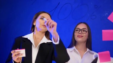 Güzel Kafkas esmeri cam duvara numaralar yazıyor. Meslektaşlar rakamları tartışıyor ve stratejiler planlıyorlar.