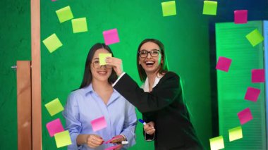 Mutlu gülümseyen beyaz kadınlar cam duvarın arkasında durur. Komik esmerler birbirlerinin alnına etiket yapıştırıp sarılıyorlar..