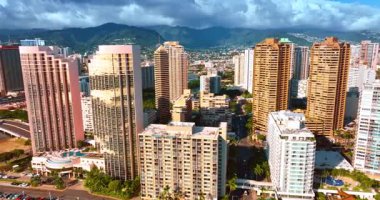 Honolulu, Hawaii, ABD şehir manzarasında çok çeşitli binalar. Dramatik bulutlar arka plandaki dağları kaplıyor.