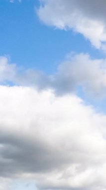 Mavi, parlak gökyüzünde ışık bulutları. Bulutların hareketli yaz mevsimi. Dikey video