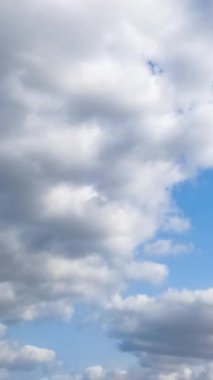 Bulutların hareketli yaz mevsimi. Mavi, parlak gökyüzünde ışık bulutları. Dikey video