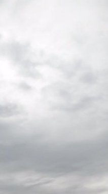 Yazın akan beyaz bulutlar. Bulutlu gökyüzü ortamında zaman kaybı. Dikey video