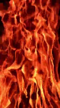 Alevli bir ateş çukuru. Kamp ateşi arka planda parlıyor. Dikey video