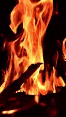 Gece şöminesi parlıyor. Şenlik ateşi yavaş çekimde ısınıyor. Dikey video