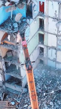 Makineyle yıkımın havadan görüntüsü. Kazı tahrip yapıları. Dikey video