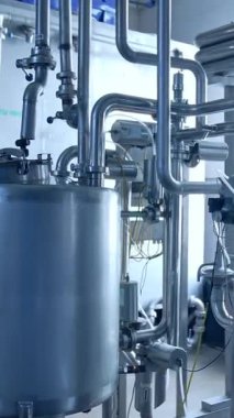 Paslanmaz tüpleri olan modern süt fabrikası. Çelik gibi büyük günlük fabrikası teknolojileri. Dikey video