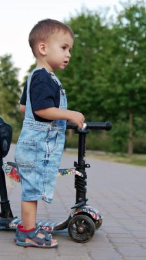 Komik sokak yaşam tarzı aktiviteleri. Çocuk scooter 'ı süren küçük bir çocuk. Dikey video