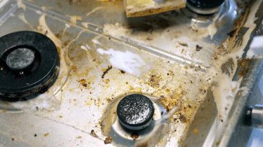 Fırını sabun ve süngerle temizliyorum. Birisi kirli bir sobayı süngerle ovalayıp temizliyor. Yağ ve lekeleri etkili bir şekilde temizliyor..