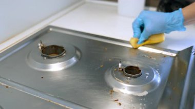 Ticari mutfağı paspaslıyorum. Mutfak çalışanı paslanmaz çelik bir yüzeyi silip öğle yemeği saatlerinde temizlik sağlıyor..