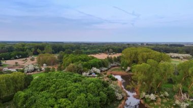 Yeşil tarlalarda alacakaranlık göleti. Alacakaranlıkta bir göleti çevreleyen yemyeşil sakin manzara doğanın güzelliğini ve sükunetini gözler önüne seriyor..