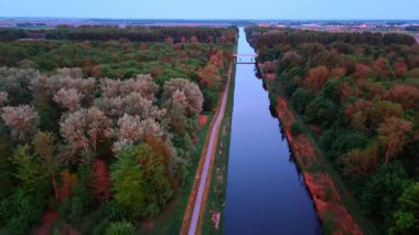 Sakin kanalda gün batımı. Gün batımında yemyeşil yemyeşil sularda uzanan sakin bir kanal durgun sulardaki sıcak renkleri yansıtır..