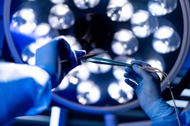 Parlak ışıklar altında ameliyat. Cerrahlar hassas bir prosedür uygularlar, parlak cerrahi ışıklar altında odaklanırlar, hassasiyet ve bakım sağlarlar..