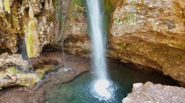 Su kristal berrak suyla gölete düşer. Kataraktlı güzel kumtaşı kayaları.