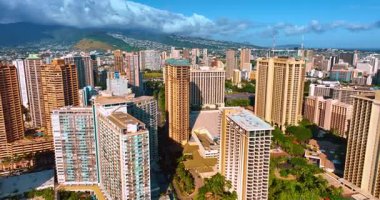 Lüks Waikiki 'nin modern mimarisi parlak güneşle aydınlatılıyor. Yağmur bulutları arka planda dağların üzerinde toplandı. Hava görünümü.