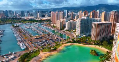 Waikiki, Honolulu, Hawaii, ABD 'deki büyük bir otopark ve yat kulübüne yaklaşıyoruz. Dağların siluetleri ve arkaplanda gri bulutlar.