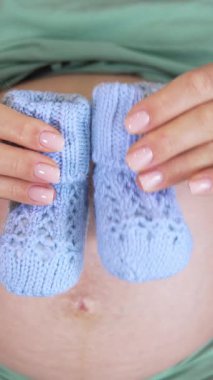 Hamile kadının etrafını sarın. Bebek çanı tutan hamile kadın manzarası