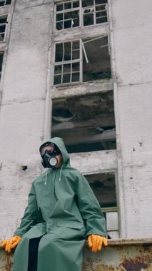 Adam harabelerin arkasında oturuyor. Nükleer kimyasal savaştan sonra takipçi kavramı hayatta kaldı