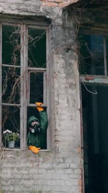 Gaz maskeli adam yıkılmış binada. Radyoaktif ortama karşı koruyucu giysi ve maske giyen adam