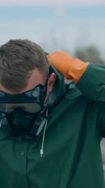 Gaz maskeli bir kıyamet adamı harabeye döndü. Gaz maskeli bir adam portresi ve harap arka planda koruyucu giysiler.
