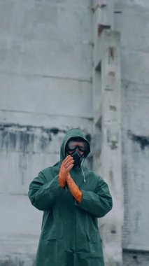 Harabelerin arasında gaz maskeli bir insan. Kıyamet sonrası ve harap bir şehirde yürüyen bir adam.