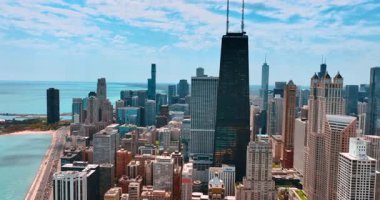 Michigan Gölü 'nün göl kıyısında uçuyor. Güneşli bir günde Chicago 'nun manzarasına bakın. Otoyol kenarındaki gölde birden fazla araba hareket ediyor..