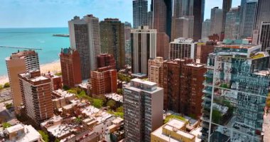 Michigan Gölü kıyısında yeşil sokakları olan parlak bir yerleşim yeri. Chicago, Illinois, ABD şehir manzarası üzerinde uçuş. Arkaplanda mavi su manzarası.