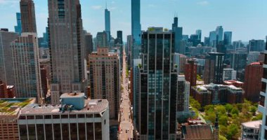 Gökdelenlerin ve gökdelenlerin arasından geçen uzun düz caddenin görüntüleri. Chicago, Illinois, ABD şehir merkezindeki uçuş.