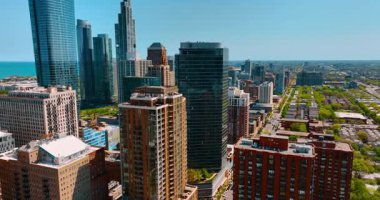 Şehrin merkezindeki yeşil parkın üzerinde yüksek binalar var. Şehir merkezindeki cam kuleye yaklaşıyoruz. Chicago, Illinois, ABD 'nin havadan görüntüsü.