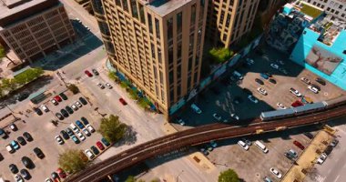 Tren, Şikago, Illinois, ABD 'de demiryolu üzerinden hareket ediyor. Üst Manzara. Birçok araba demiryolunun altında park halinde..