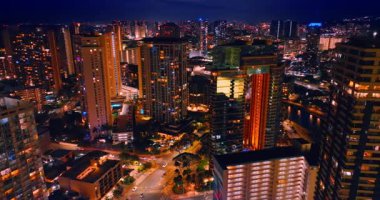 Arabalar geceleri iyi aydınlatılmış şehir yollarıyla çalışır. Parlak Honolulu 'nun muhteşem manzarası, Hawaii, ABD geceleri. Hava görünümü.