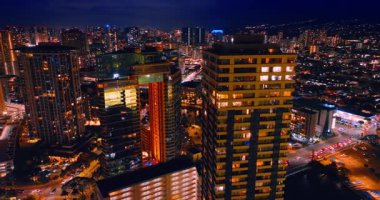 Gökdelenlerin tepesinde uçarken pencerelerde ışıklar yanıyordu. Ala Wai Kanalı yakınlarındaki Waikiki sahnesinden görüntüler Honolulu, Hawaii, ABD 'de gece.