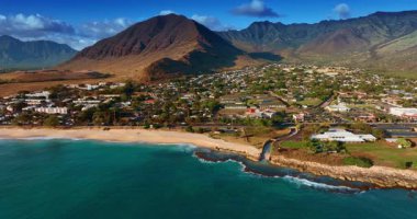 Engebeli çıplak dağlarla çevrili güzel bir yerleşim yeri. Pasifik Okyanusu 'nun su yüzeyinden insansız hava aracı görüntüleri. Honolulu, Hawaii, ABD.