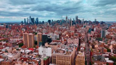 Modern metropolün yüksek nüfuslu şehir manzarasının üzerine iniyor. Arka planda New York 'un gökdelen silueti. Gökyüzünü kaplayan yağmur bulutlu bir manzara..