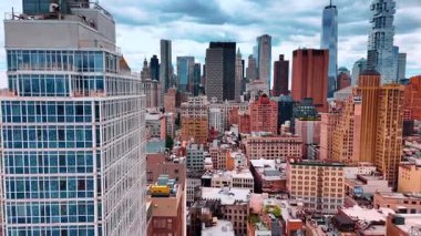 Modern metropolün çeşitli kentsel manzaraları arasında uçmak. Şehir merkezindeki bulutlu gökyüzünün altında New York 'un muhteşem gökdelenlerine yaklaşıyoruz..