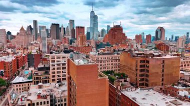 New York şehir merkezine gidiyorum, yerleşim alanının üstünde uçuyorum. Gökdelenler bulutlu gökyüzünün arka planında.