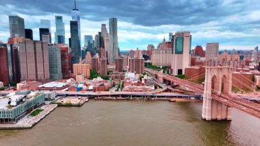 Brooklyn Köprüsü 'nün başladığı New York rıhtımına daha yakın uçuyorum. Arkaplanda gri gökyüzünün altındaki gökdelenler.