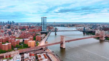 Kasvetli bir günde ikonik New York 'un güzel manzarası. Rıhtımın yukarısındaki insansız hava aracı görüntüleri. Yollarda trafik çok hareketli. Brooklyn Köprüsü 'nün ve Doğu Nehri üzerindeki Manhattan Köprüsü' nün üst manzarası..