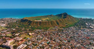 Mavi su manzarasının arka planında devasa bir volkanik elmas başlıklı kraterin çarpıcı görüntüsü. Honolulu, Oahu, Hawaii 'deki meskûn evler şehrin çevresini sarar. Hava perspektifi.