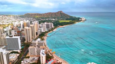 Dalgalar Waikiki, Hawaii, ABD 'nin güzel kıyılarına ulaşır. Arkaplandaki elmas başlıklı kraterin muhteşem manzarası.