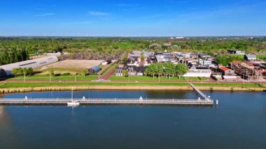 Hollanda, Lelystad 'ın güzel, pitoresk kıyı şeridi boyunca görüntüler. Güzel evlere, depolara ve telekom kulesine bakın..