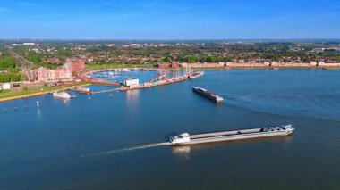 Hollanda 'nın Lelystad limanı yakınlarında iki uzun ve boş mavna. Markermeer Gölü 'nün rıhtımında yemyeşil hava perspektifi.