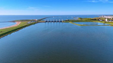 Hollanda, Lelystad 'daki Markermeer Gölü' nün pürüzsüz yüzeyi. Arka planda su kanalları ve yelkenli barajlara bak.