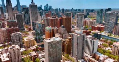 Chicago şehir merkezinin güneşli modern manzarası. Gökdelenlere yaklaşan yüksek binaların üzerinden insansız hava aracı uçuşu.
