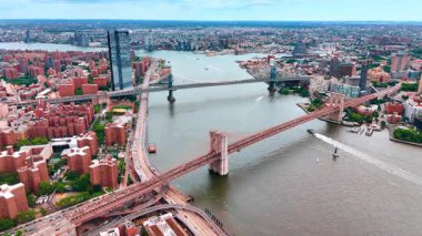 Doğu Nehri manzarası ABD 'nin New York şehrinden geçiyor. Tekneler Brooklyn ve Manhattan Köprülerinin altından geçiyor. Hava perspektifi.